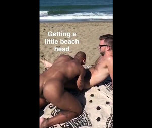 Meaty ebony fellow blowing man's stiffy on the beach